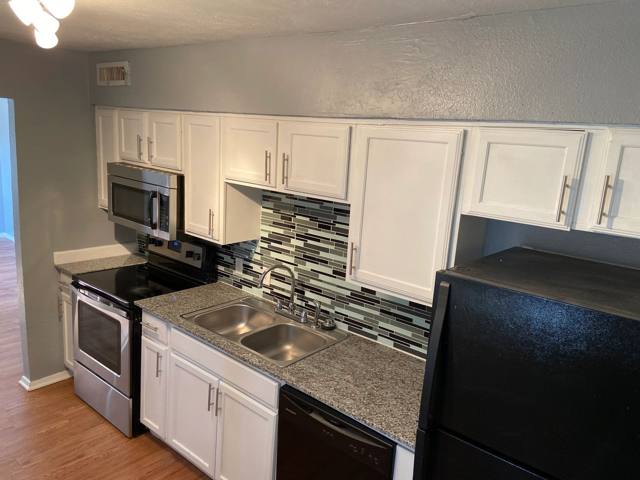 Kitchen with stainless microwave and granite-look counters